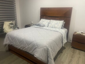 Cozy retreat with a large bed, two nightstands, and a plush chair.