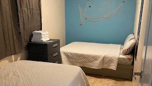 A bedroom with two beds, a ceiling fan, and a hammock. - Cayo Collado at Guayacán Guest House (Lajas)