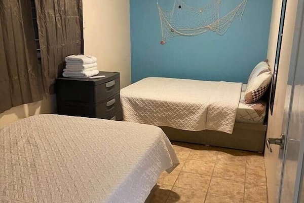 A bedroom with 2 confortable full beds to accommodate up to 4 people. An inverter air conditioned, ceiling fan and a drawer.