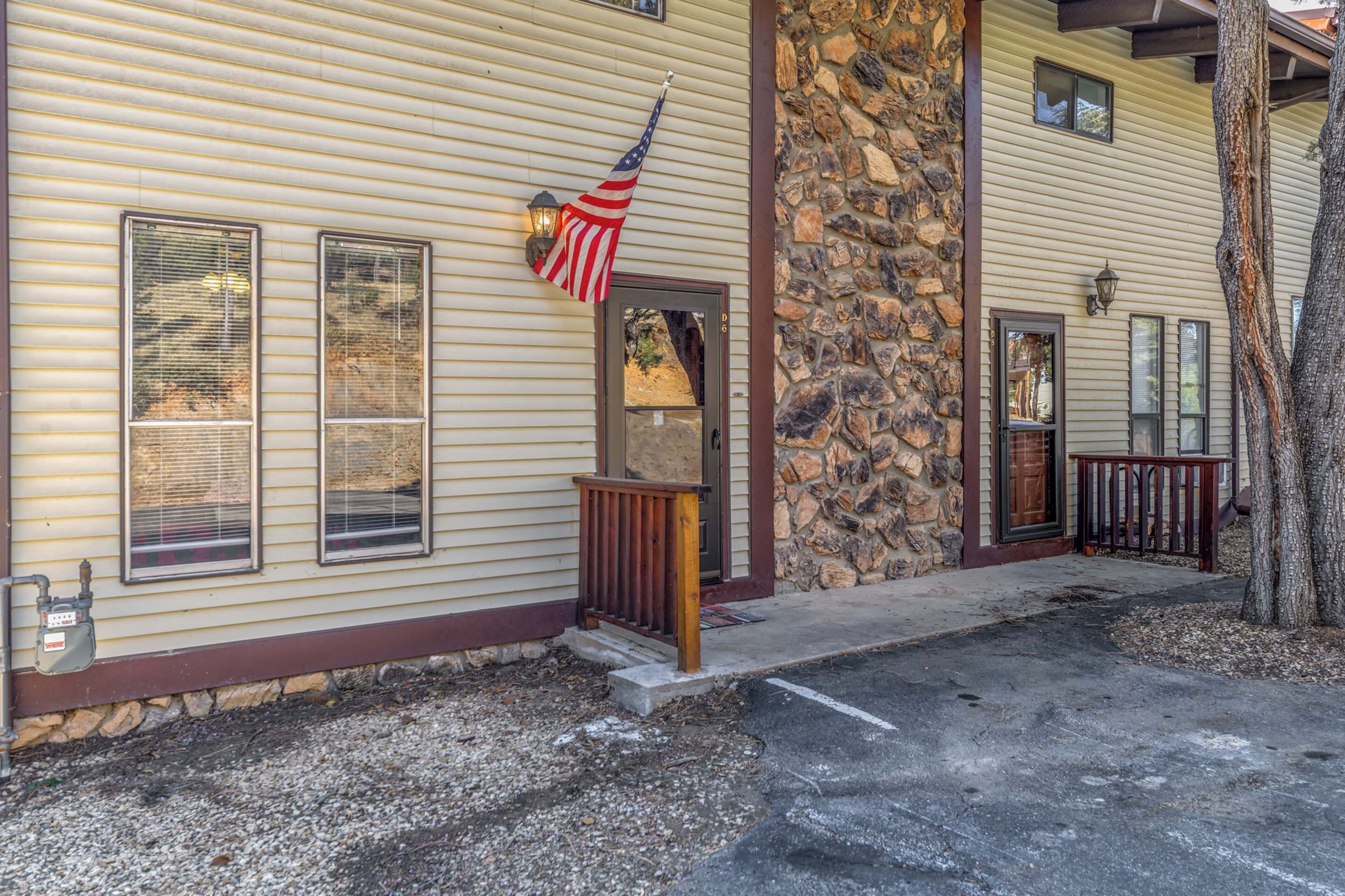 Un edificio con fachada de piedra, puerta de madera y una bandera estadounidense.
