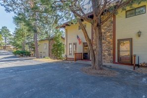 A row of yellow buildings with stone accents, a flag, and a paved driveway.