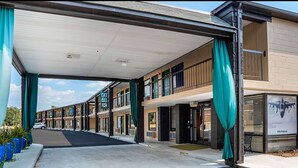 A hotel with a covered outdoor area, multiple rooms, and a visible entrance. - Super 8 by Wyndham Daleville/Fort Novosel (Daleville)