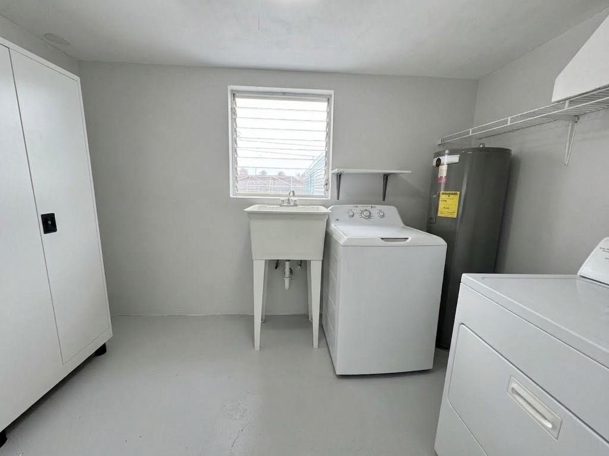A laundry room with a washing machine, a dryer, and a utility cabinet.
