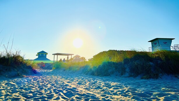 A beach with a lifeguard tower, a covered pavilion, and a sandy area. - Treasure Coast Pool Home - Walk to Downtown Jensen Beach. (Jensen Beach)