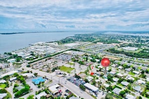 En vy över en kuststad från ovan, med en småbåtshamn, bostadsområden och en stor röd ballong.