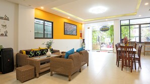 A modern living room with a sofa set, dining table, and chairs. - HOIANIAN CENTRAL VILLA (Da Nang)