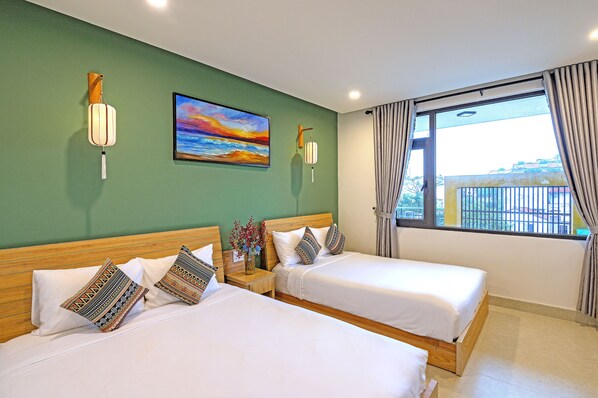 Una habitación de hotel con dos camas, un cuadro en la pared y una ventana con cortinas.