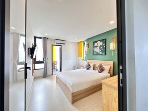 A modern hotel room with a bed, bedside table, and a painting on the wall. - HOIANIAN CENTRAL VILLA (Da Nang)