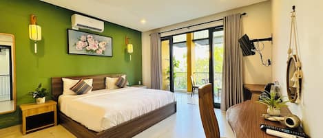 A hotel room with a bed, bedside table, and a desk with a chair.