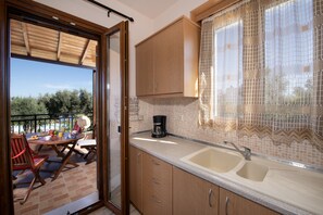 A kitchen with wooden cabinets, a sink, and a coffee maker.