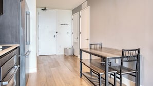 A modern kitchen with stainless steel appliances, a wooden dining table, and chairs. - City Limits by AvantStay (Austin)