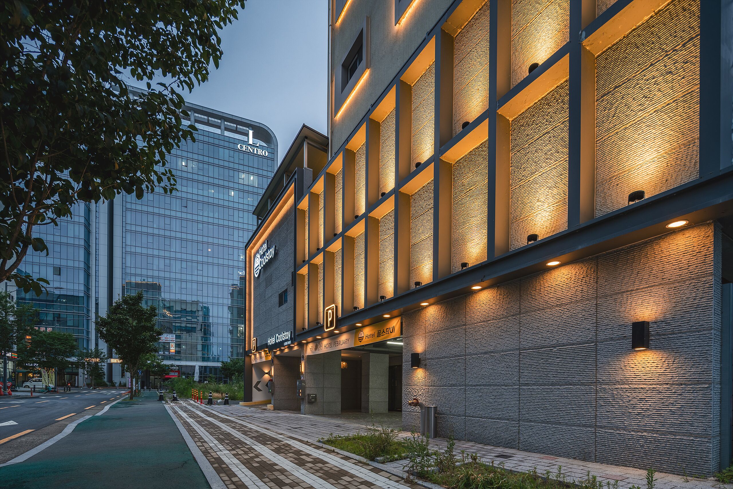 A modern hotel building with a glass facade and a brick exterior.
