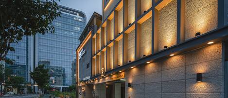A modern hotel building with a glass facade and a brick exterior.