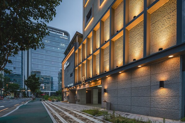 A modern hotel building with a glass facade and a brick exterior.