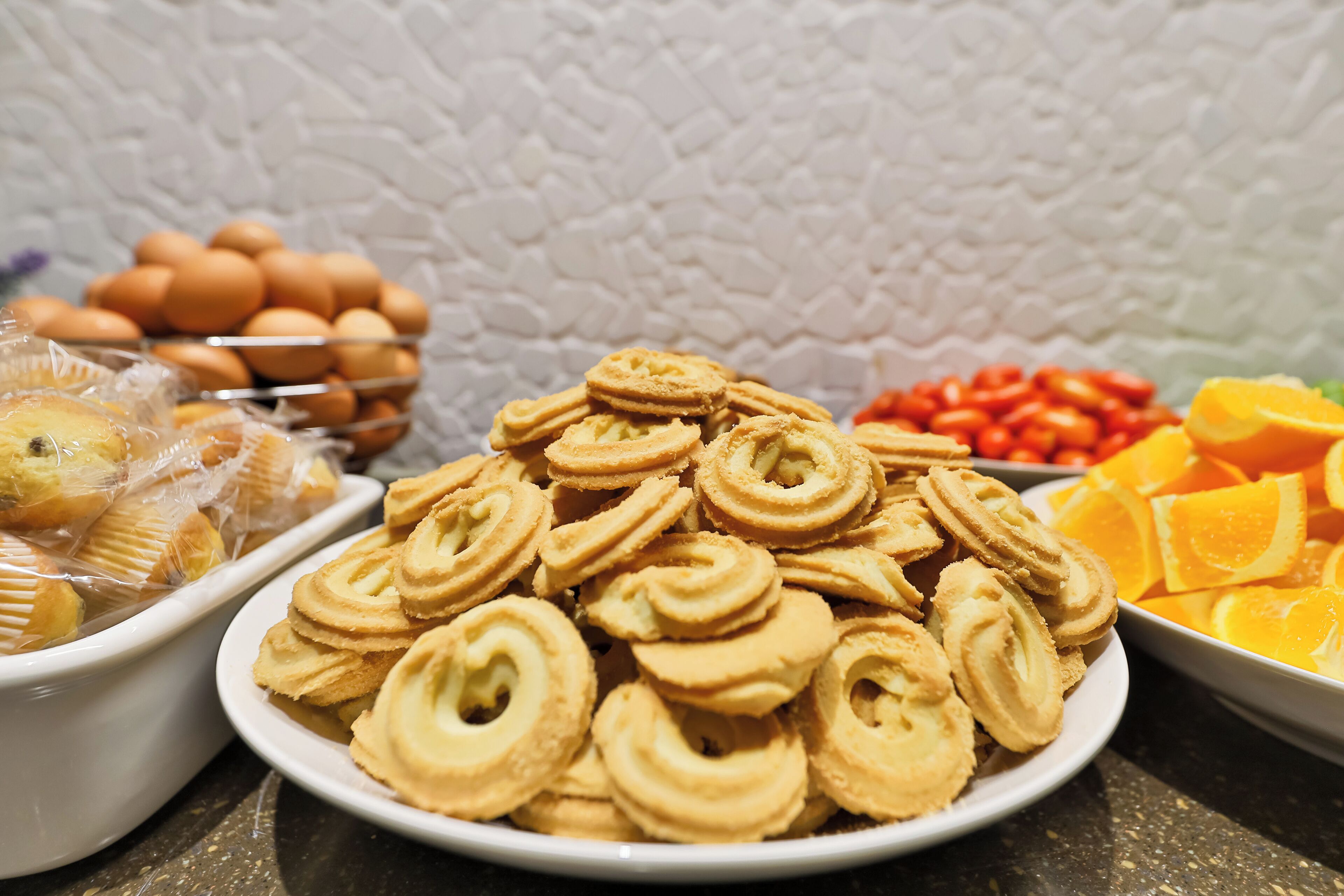 A variety of baked goods including cookies, eggs, and sliced oranges.