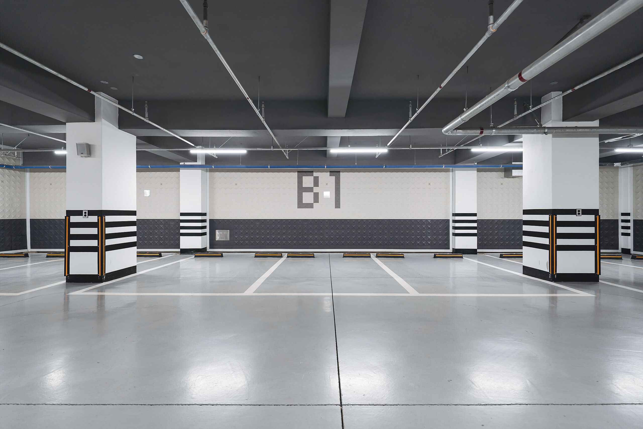 A spacious parking garage with clear markings for parking spaces, a prominent 'B1' sign, and a clean, well-lit environment.