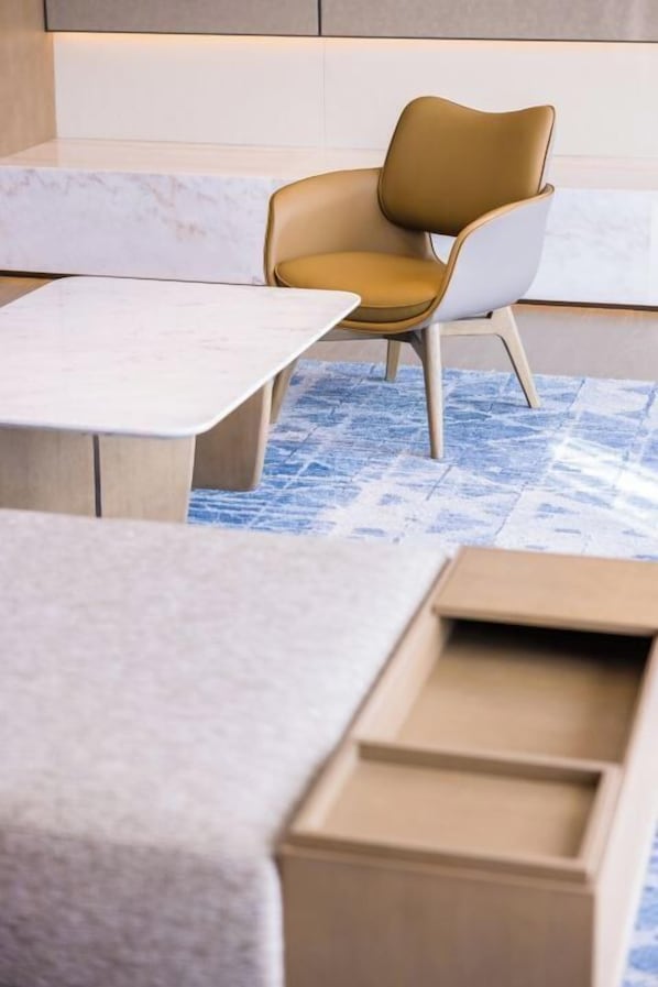 Un interior moderno con una encimera de mármol, un sillón de cuero marrón y una alfombra estampada.