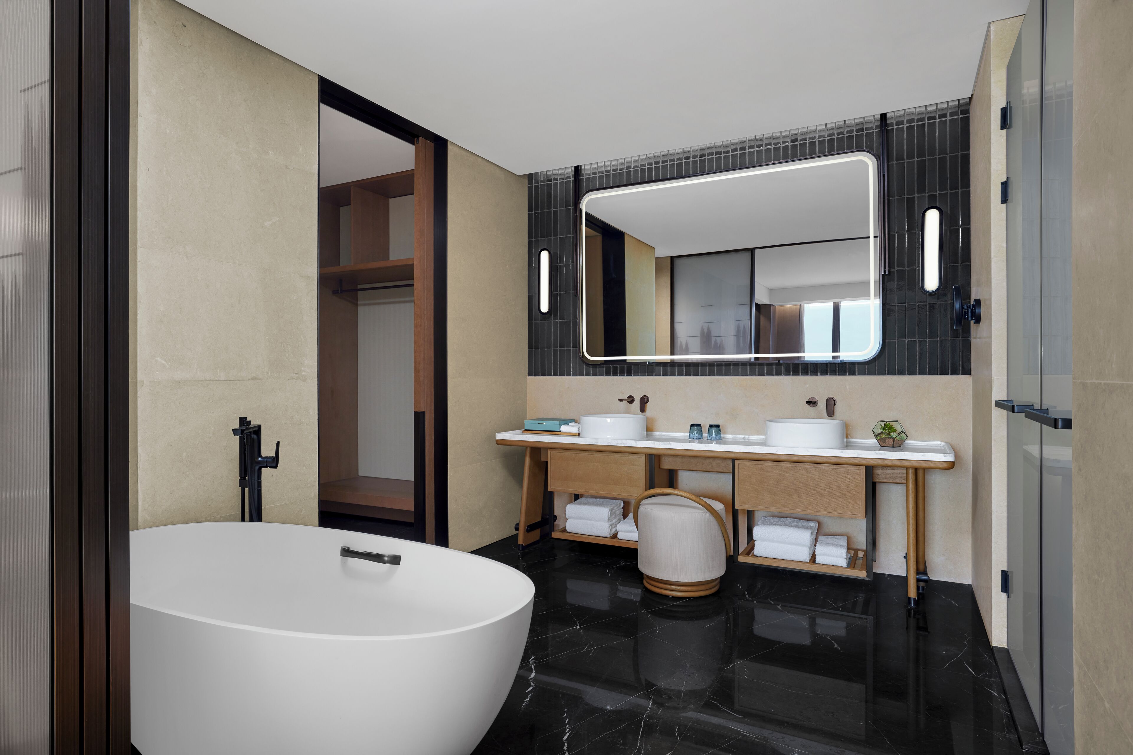 A modern bathroom with a freestanding bathtub, a vanity with a mirror, and a toilet.