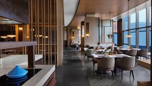 A modern hotel lobby with a spacious layout, featuring a mix of seating areas and a central bar. - Nantong Marriott (Nantong)