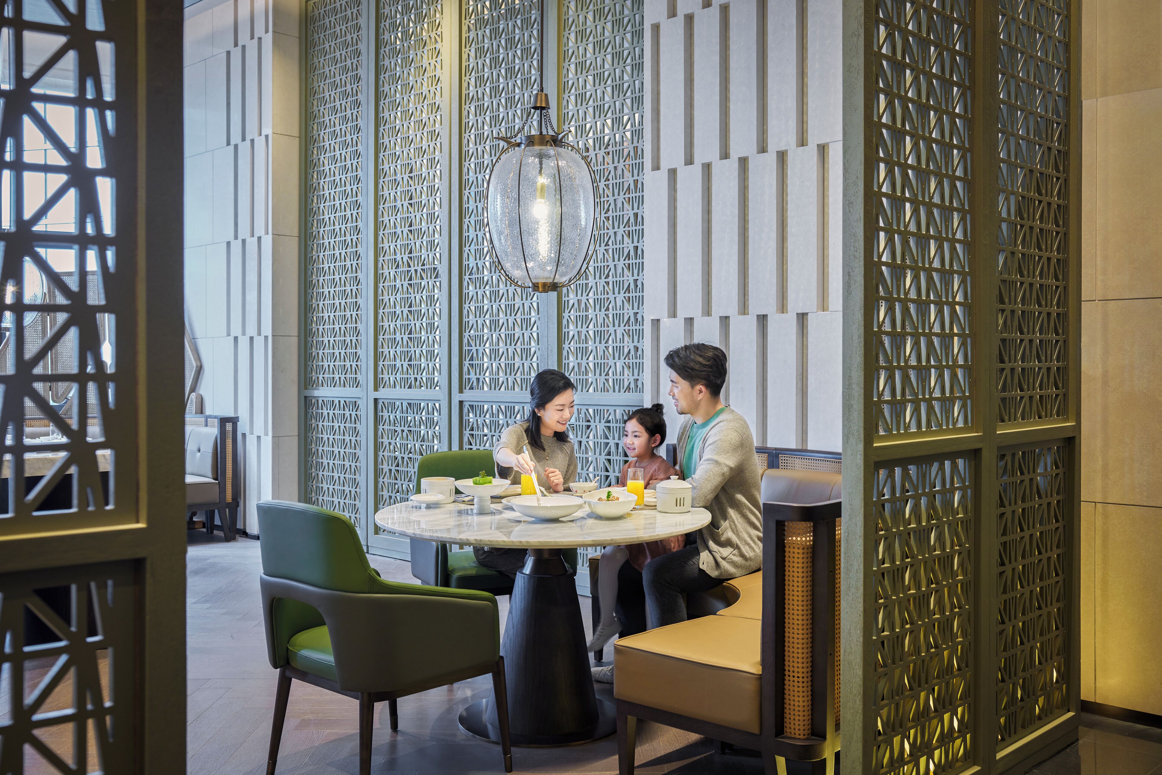 Un espace repas moderne avec une table ronde, des chaises et un luminaire décoratif.