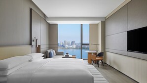 Une chambre d’hôtel moderne équipée d’un grand lit, d’un bureau, d’une chaise et d’une télévision.