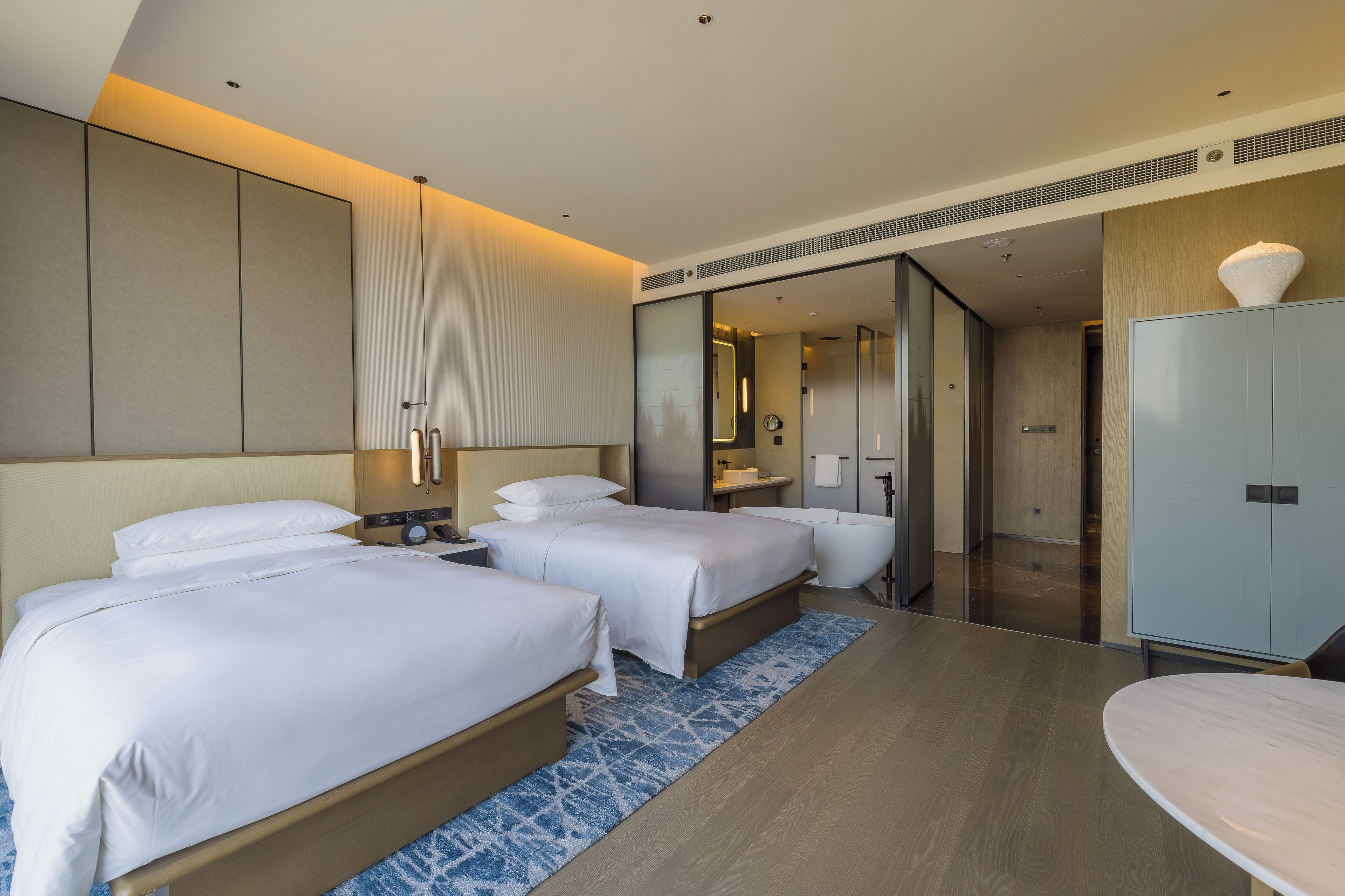 Habitación de hotel con dos camas, un baño y un armario.