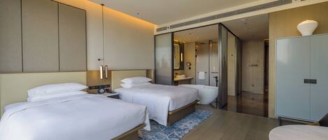 Habitación de hotel con dos camas, un baño y un armario.