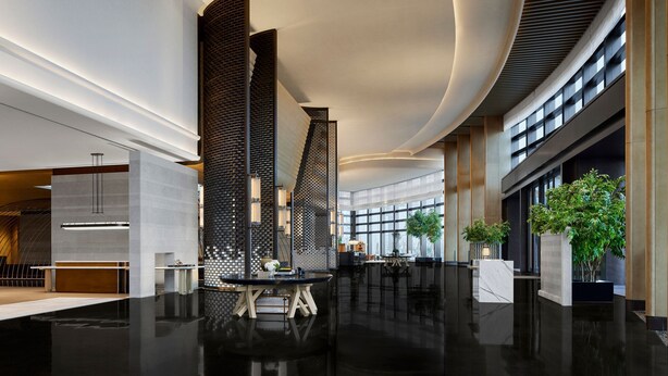 A modern lobby with a sleek design, featuring a central black partition, polished floors, and natural light from large windows. - Nantong Marriott (Nantong)