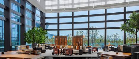 Un espacio interior amplio con ventanas grandes, muebles modernos y vistas al exterior.