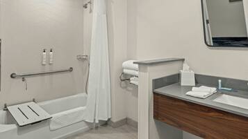 A modern bathroom with a bathtub, shower, and vanity.