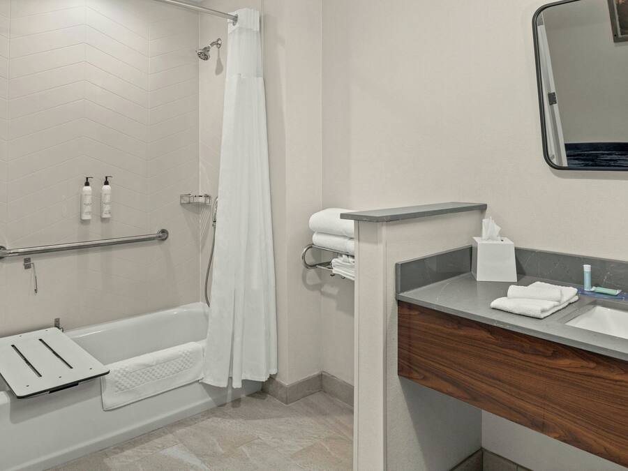 A modern bathroom with a bathtub, shower, and vanity.