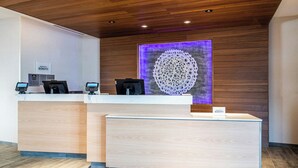 Un comptoir d’accueil d’hôtel avec deux guichets, un plafond en bois et un élément décoratif mural.