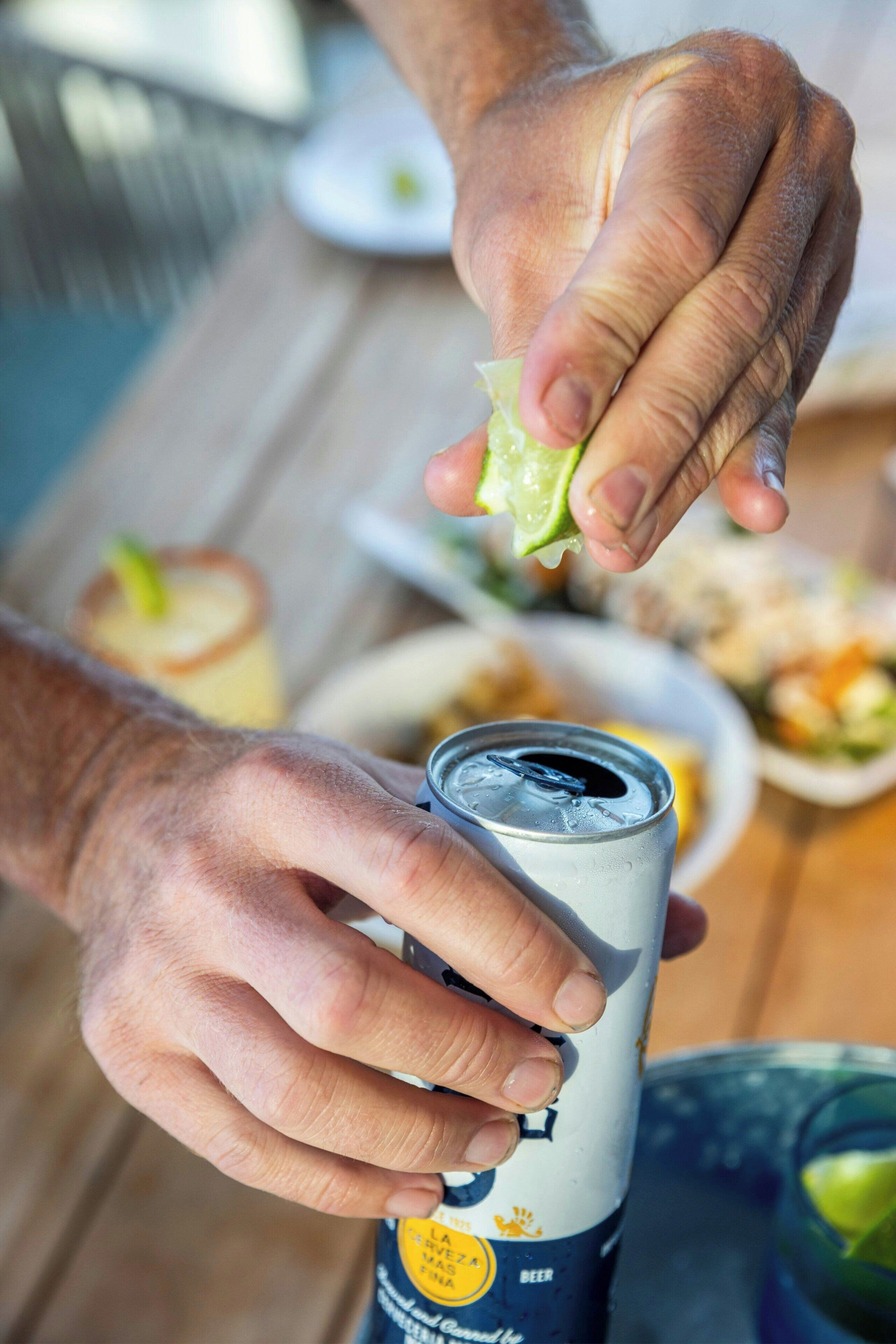 Una persona che apre una lattina di birra.