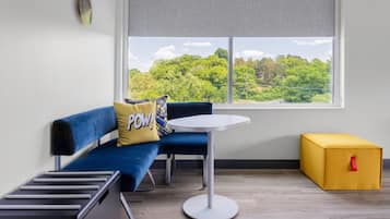 Una habitación moderna con un sofá azul, una mesita blanca y un caja de almacenamiento amarilla.