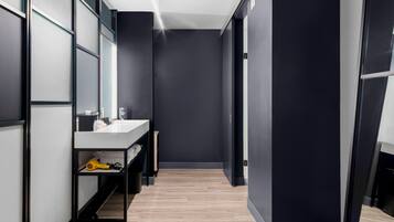 Un baño moderno con lavamanos, espejo y toallero blancos.