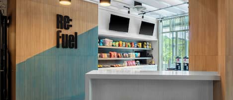 A modern interior with a counter, seating, and a wall with 'Re: Fuel' signage.