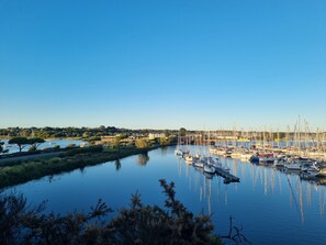 Uma marina com barcos atracados, águas calmas e céu limpo.