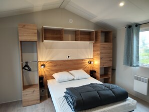 Um quarto moderno com cama, estantes embutidas e janela com cortinas.