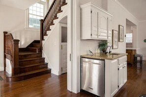 Stylish living area with a staircase leading to an upper level, a modern kitchen, and a clean design.