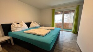 Un dormitorio con cama, un banco y vistas al exterior.