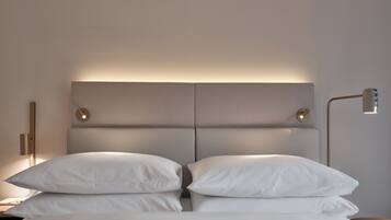 Un letto con una testiera, due lampade da comodino e un comodino.