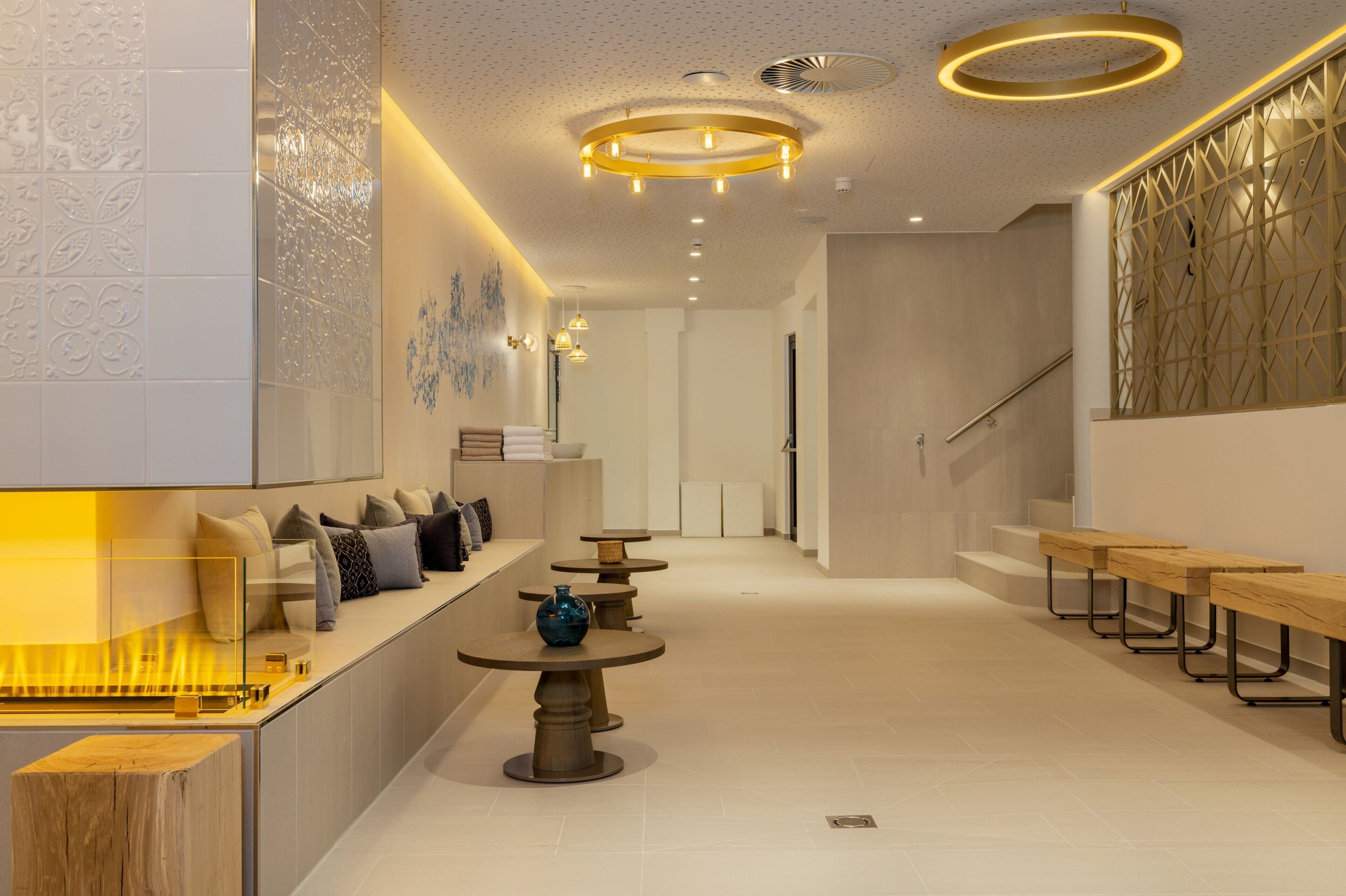A modern lobby with a seating area, a staircase, and a reception desk.