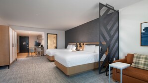 Une chambre d’hôtel moderne dotée d’un grand lit, d’un bureau, d’un canapé et offrant une vue sur la ville.
