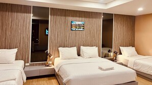 Een moderne hotelkamer met een groot bed, twee nachtkastjes, een spiegel en een aan de muur bevestigde televisie.