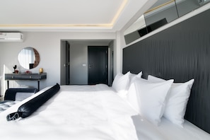 A modern hotel room with a large bed, a bedside table, a mirror, and a dark headboard. - Via Çırağan Hotel (Istanbul)