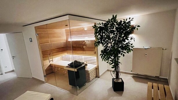 Une pièce moderne et compacte, dotée d’une banquette intégrée, d’une plante en pot et d’une petite table.