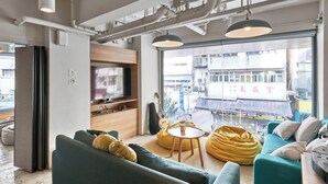 A modern living room with a sofa, a coffee table, and a bean bag. - Weave Studios - Prince Edward (Kowloon)