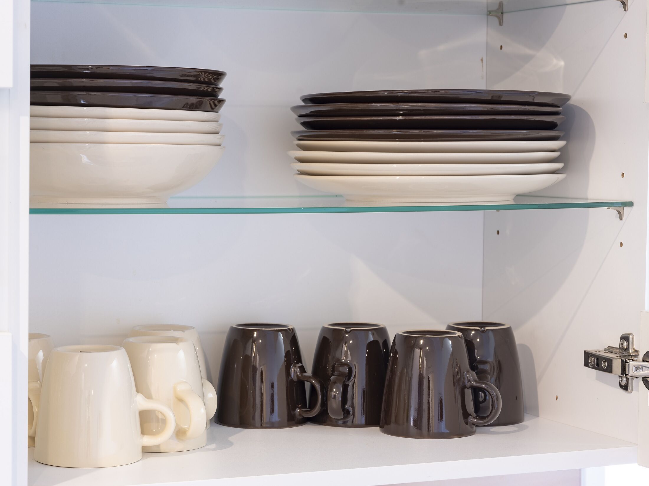 Une collection d’assiettes et de tasses en céramique exposée sur des étagères.