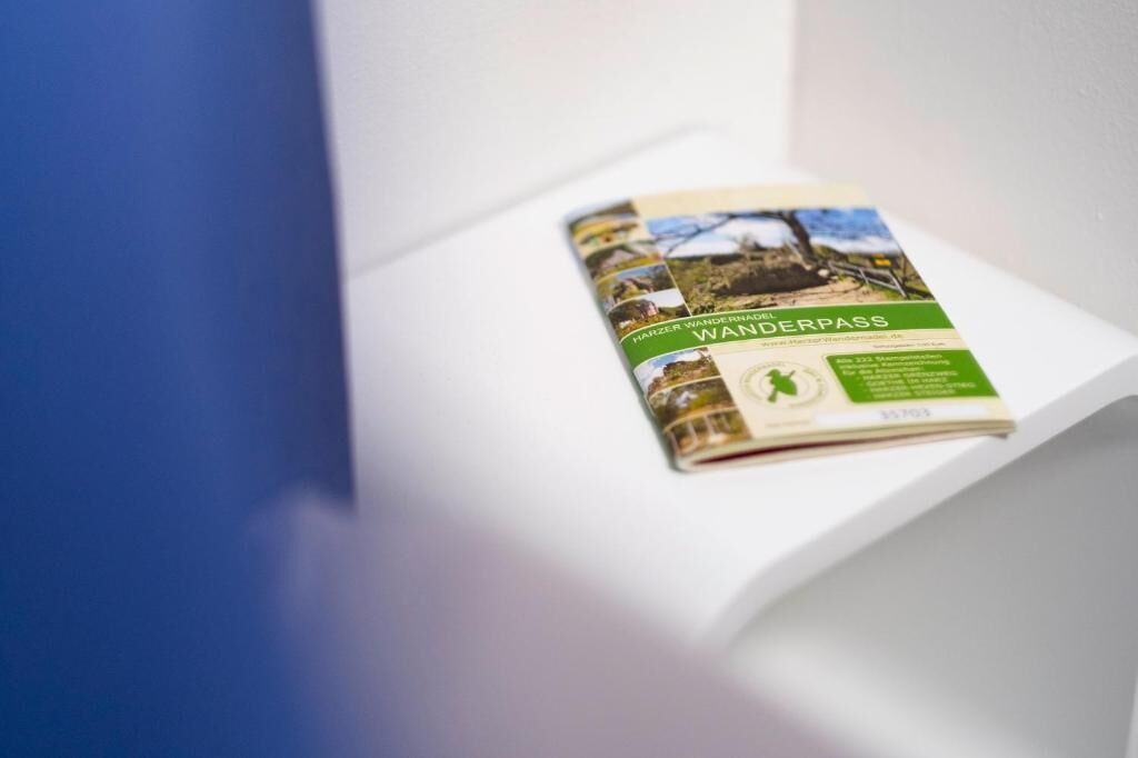 A brochure titled "Harzer Wanderpass" on a white shelf.