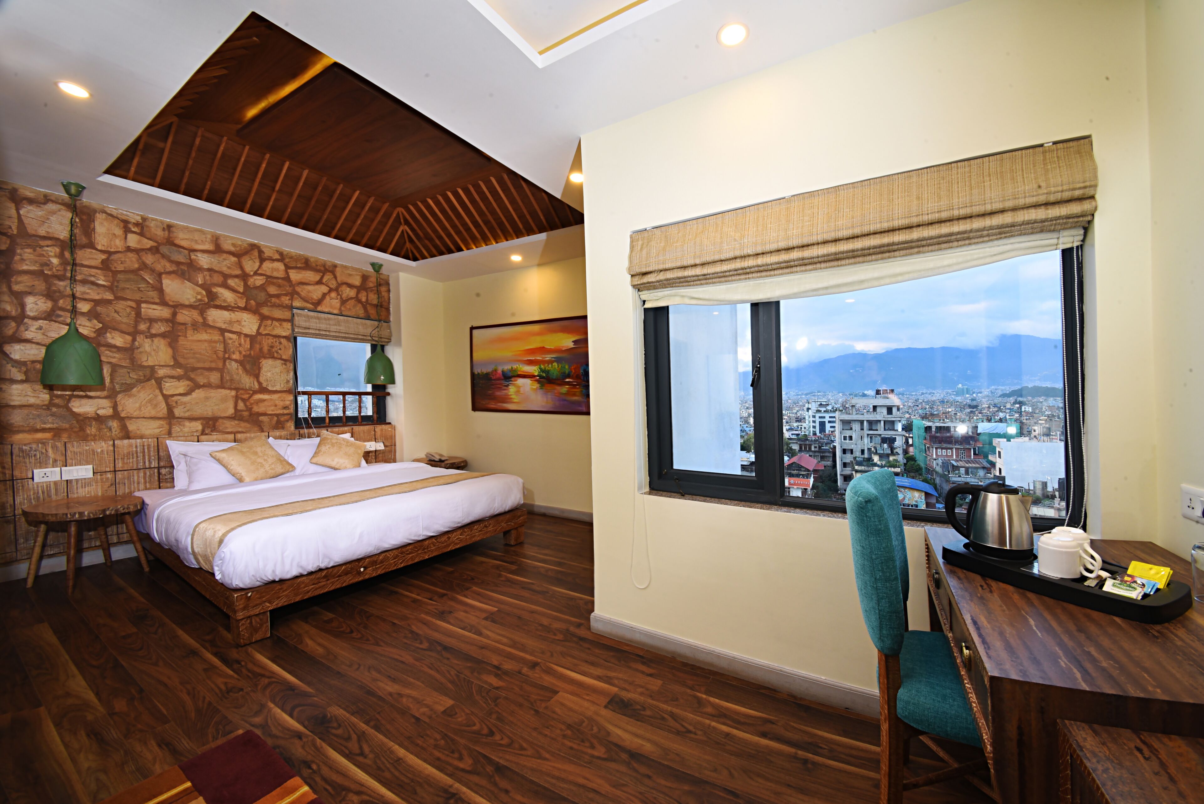 A bedroom with a large bed, a view of the city, a wooden ceiling, and a stone wall.